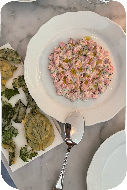 Pink tartare dish on white plate with tempura vegetables