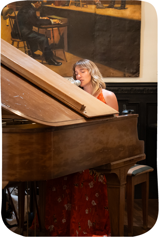 Woman in red floral dress playing piano