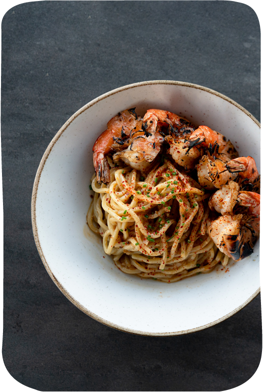 Pasta dish with shrimp in white bowl