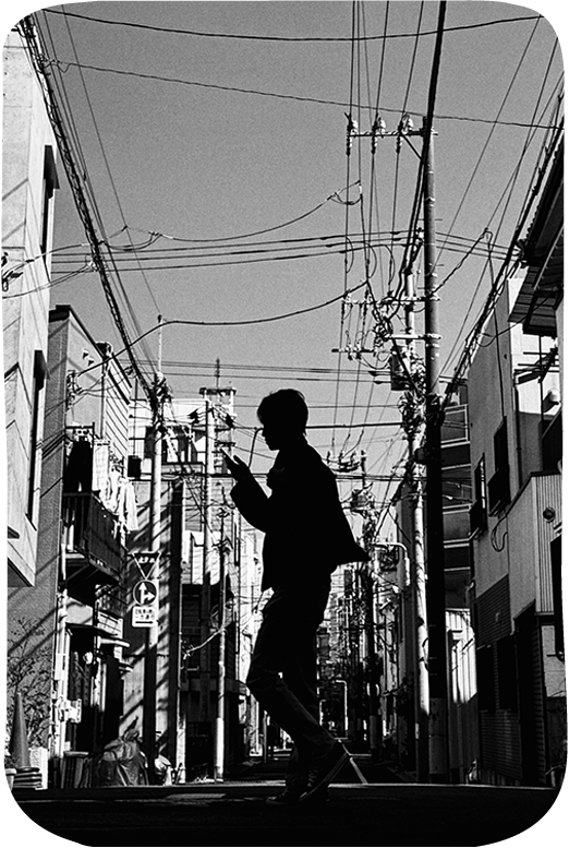 Black and white silhouette of person walking on street